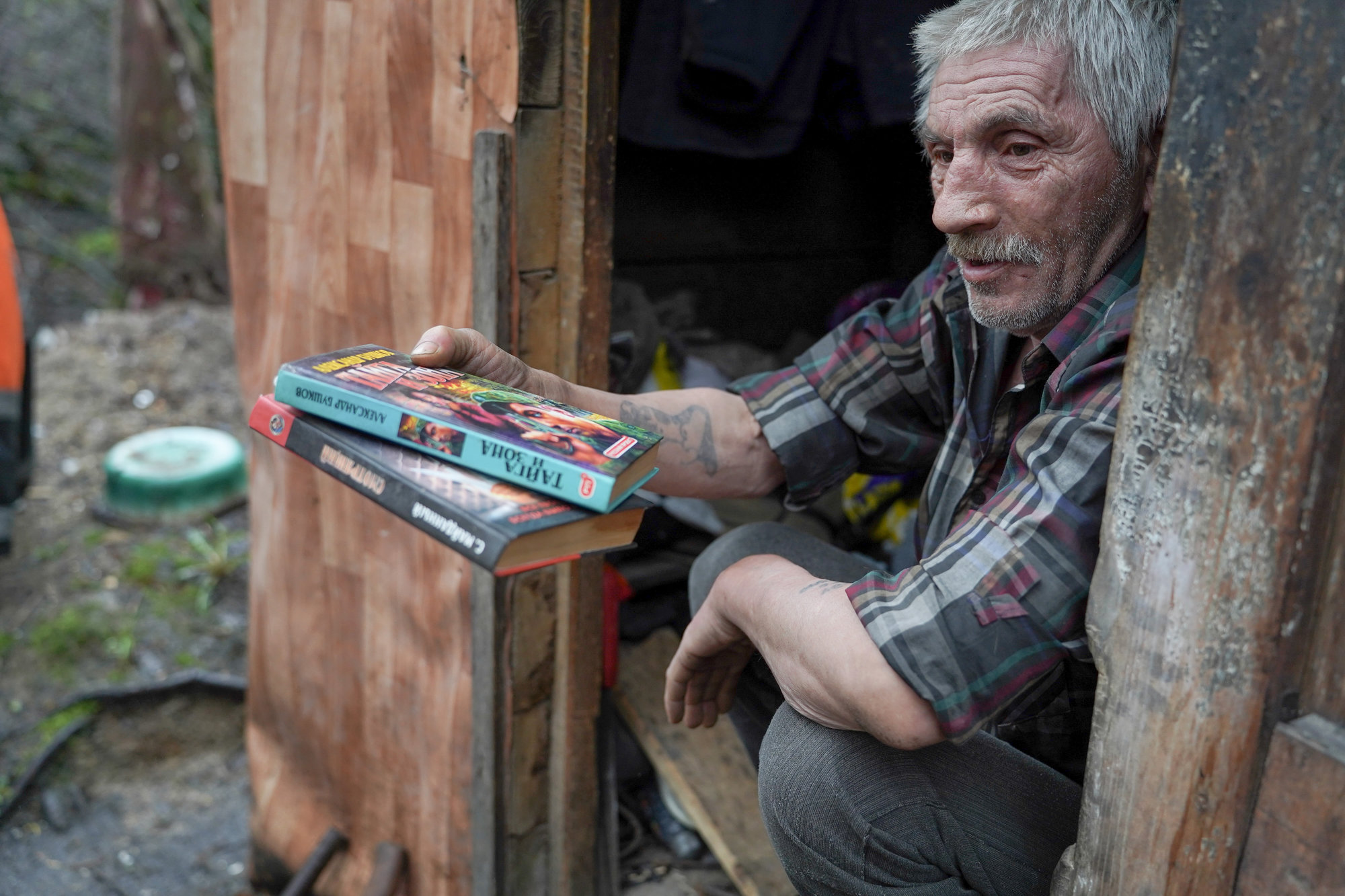 Евгений с удовольствием показывает свои татуировки и книги. Фото: «Бумага»